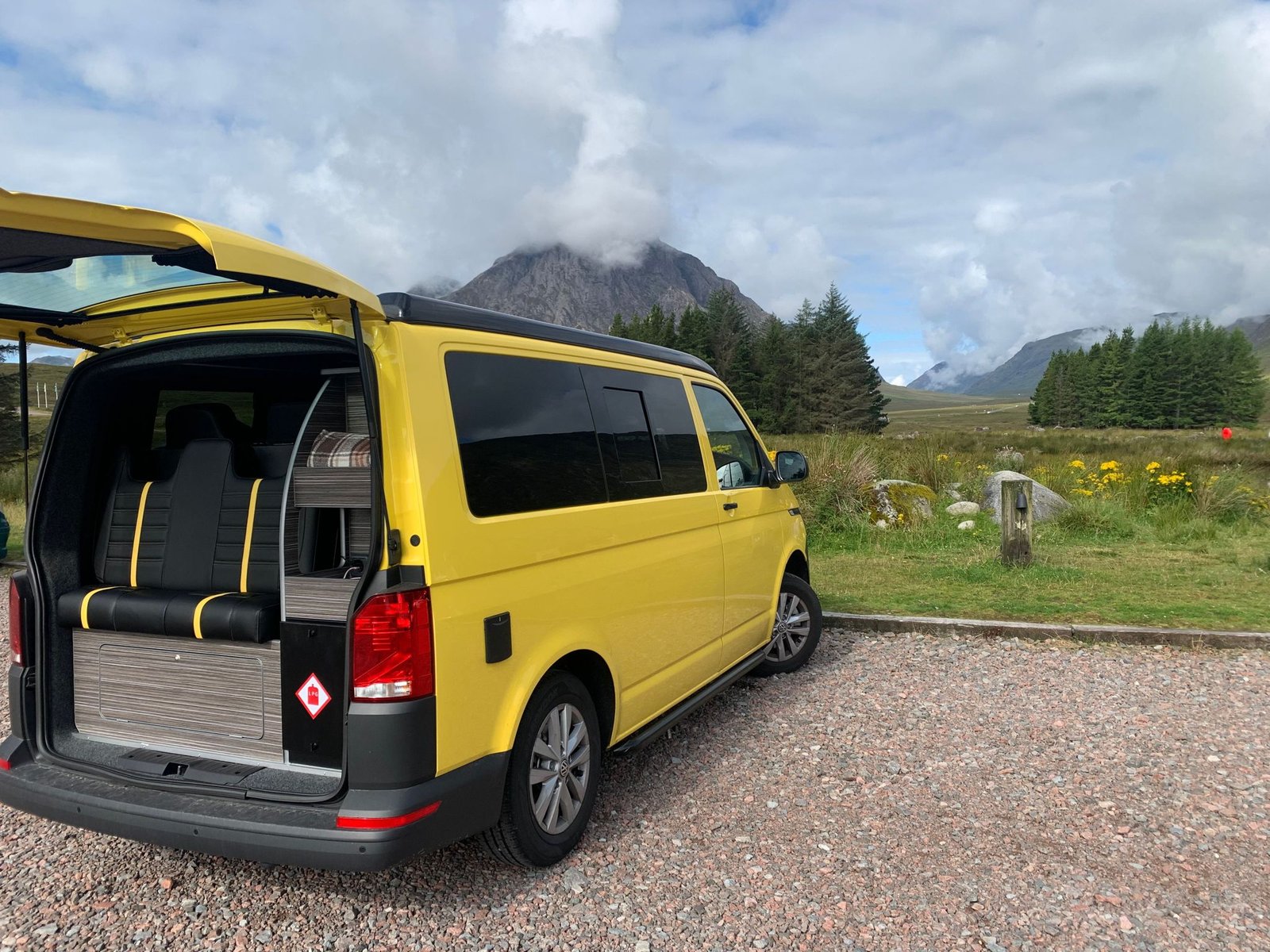 Tailgate raised on VW Campervan with Scottish mountain scene in the background.