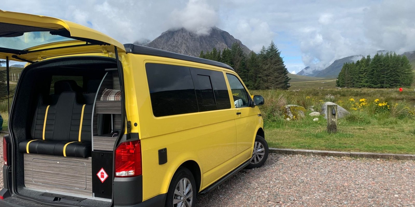 Tailgate raised on VW Campervan with Scottish mountain scene in the background.